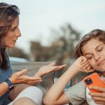 Mom talking to young teen son who is on his smart phone; how to initiate healthy conversations about porn with your teen